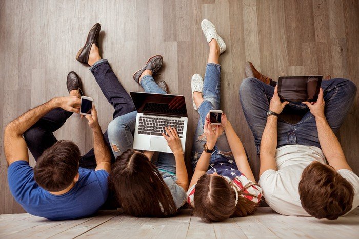 Famille utilisant différents appareils mobiles.