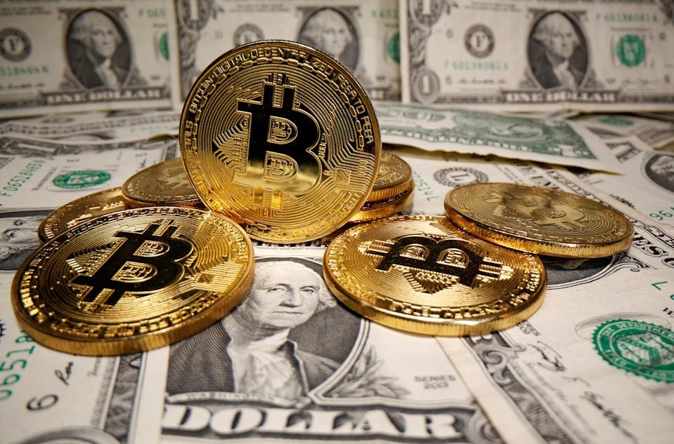 Des représentations de la monnaie virtuelle Bitcoin sont placées sur des billets en dollars américains dans cette illustration prise le 26 mai 2020. REUTERS/Dado Ruvic/Illustration