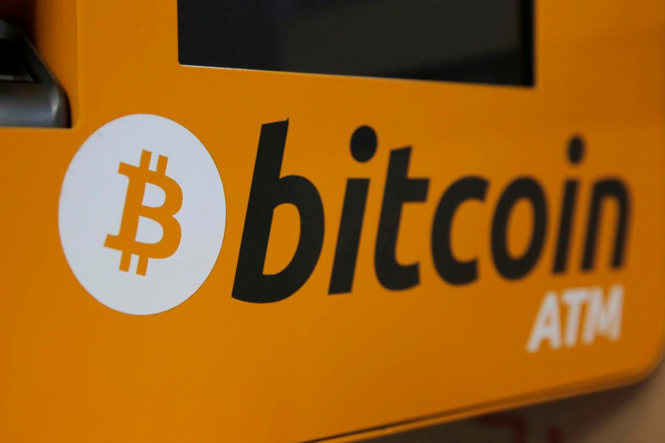 DOSSIER - Un logo Bitcoin est affiché sur un guichet automatique à Hong Kong, le jeudi 21 décembre 2017. Un expert en crypto-monnaie a été condamné le mardi 12 avril 2022 à plus de cinq ans de prison fédérale pour avoir aidé la Corée du Nord à échapper aux sanctions américaines.  (AP Photo/Kin Cheung, Fichier)