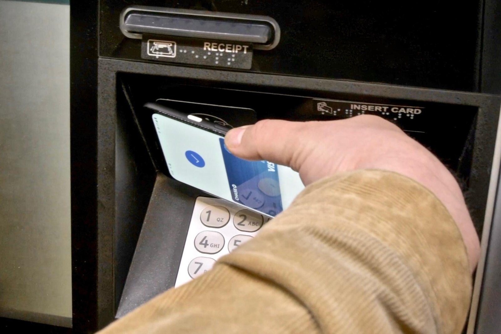 Voici tout ce que vous devez savoir sur l'utilisation de Google Pay et tous ses avantages 4 Taper sur un téléphone Android avec Google Pay à un guichet automatique pour obtenir de l'argent