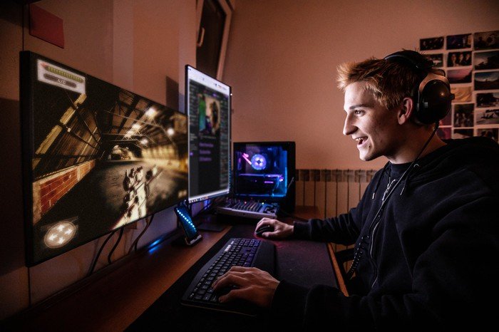 Une personne sourit en jouant à un jeu vidéo.