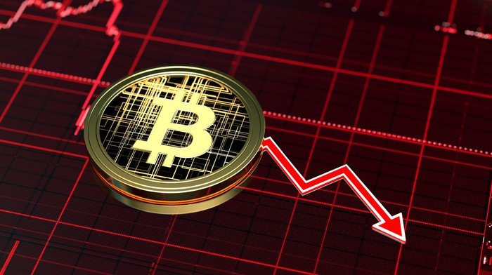 Une illustration d'un Bitcoin sur un graphique en déclin.
