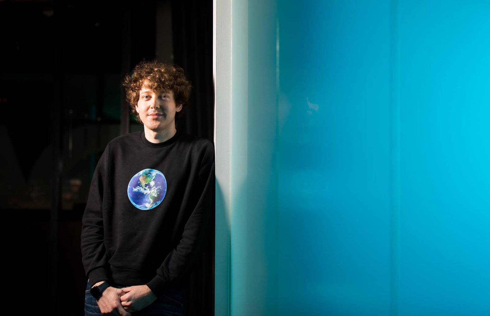 Charles Lamanna, vice-président de Microsoft chargé des applications et de la plate-forme d'entreprise, est représenté appuyé contre un mur.
