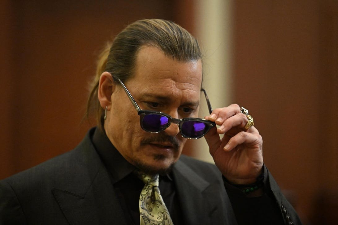 Why Johnny Depp vs. Amber Heard Dominated the Internet 1 Johnny Depp in a suit, removing his sunglasses.