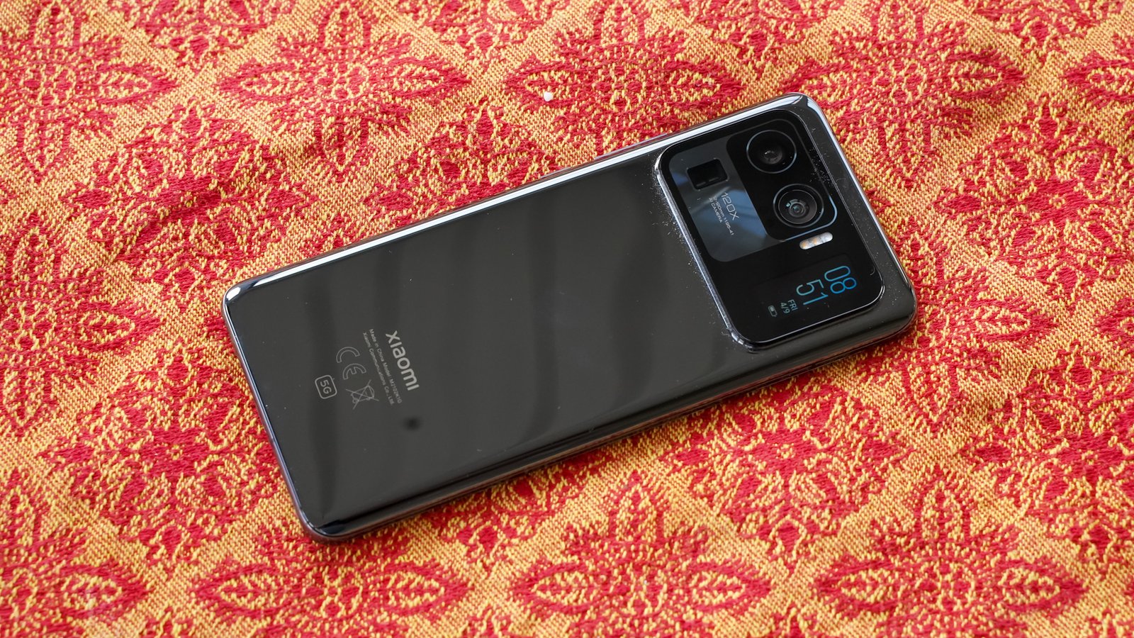 Xiaomi Mi 11 Ultra hero shot Xiaomi Mi 11 Ultra on a red and gold patterned background, showing the rear of the phone and camera module