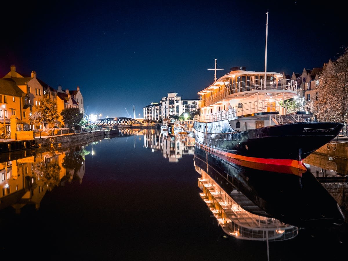 Prenez des photos incroyables avec ces conseils de photographie pour iPhone 13 4 bateaux sur un quai illuminé la nuit