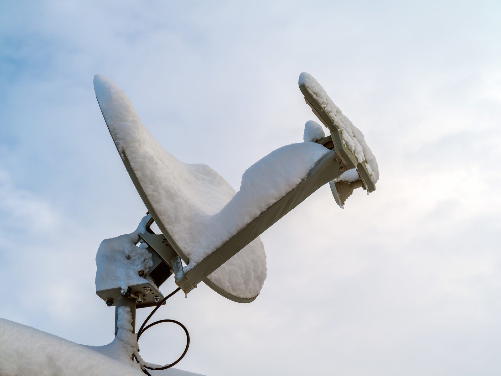 Antenne parabolique sur le toit couverte de neige
