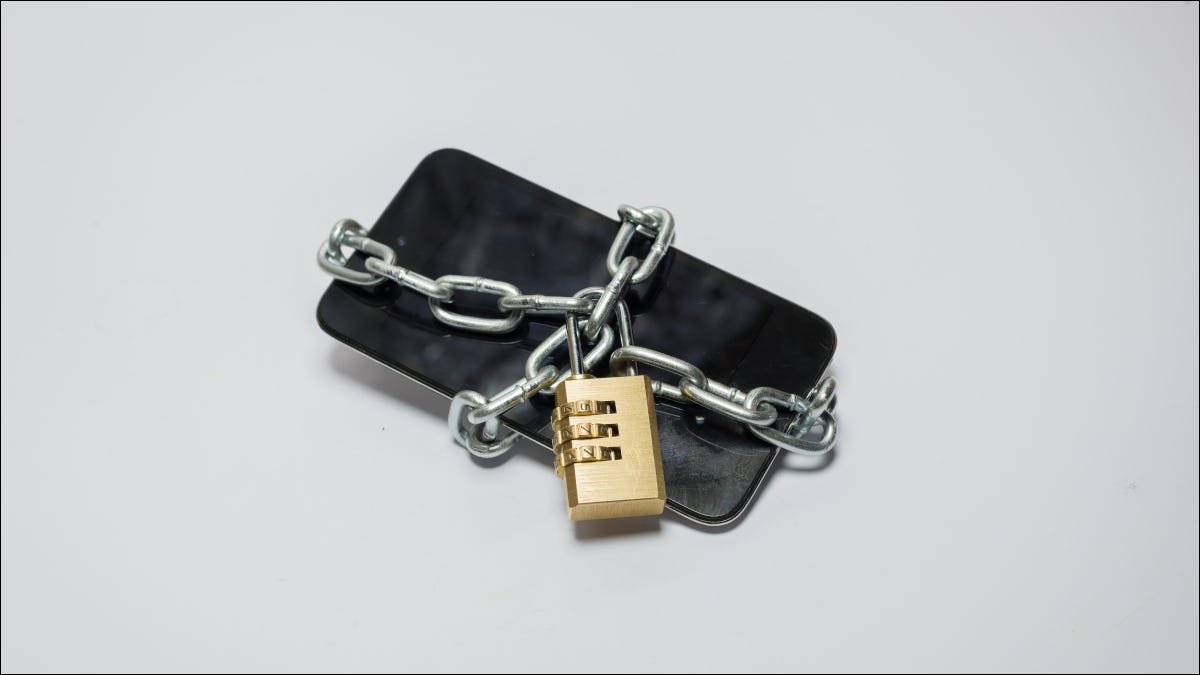 Smartphone enveloppé dans une chaîne en métal avec un cadenas le sécurisant.