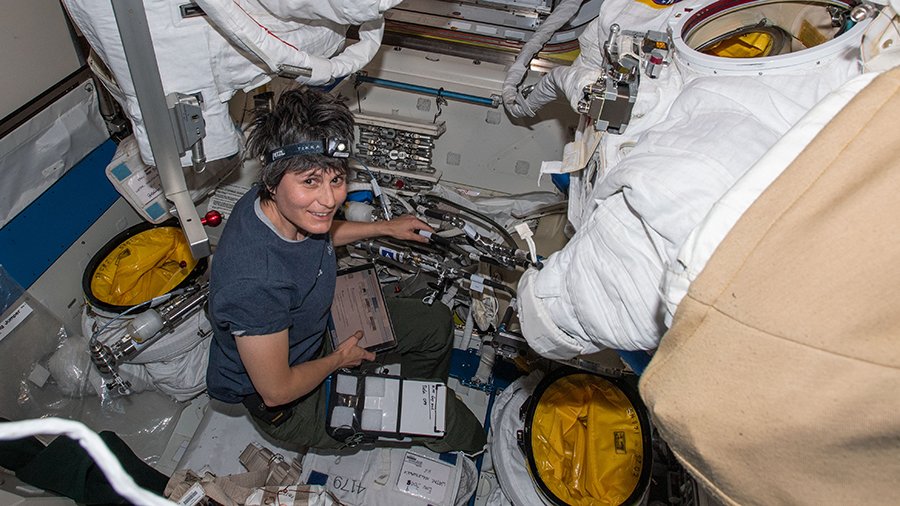 L'astronaute Samantha Cristoforetti travaille sur des combinaisons spatiales américaines à l'intérieur du sas Quest de la Station spatiale internationale.