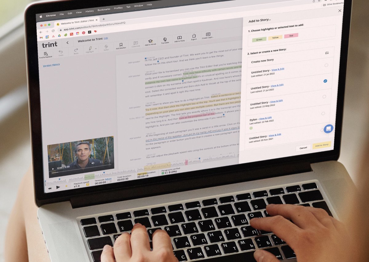Personne tapant sur un ordinateur portable avec Trint à l'écran