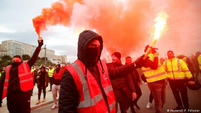 Les manifestants allument des fusées éclairantes rouges pendant la grève générale française Les manifestants allument des fusées éclairantes rouges pendant la grève générale française