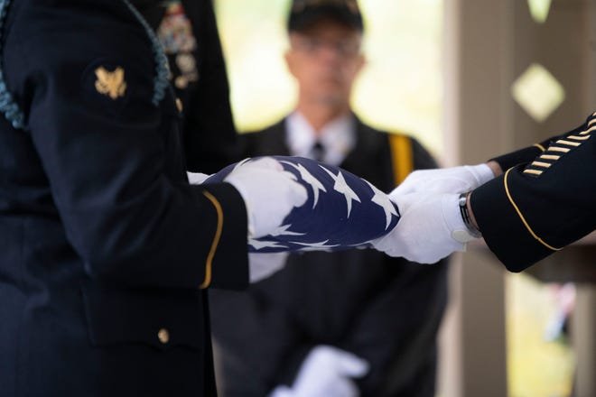 Les membres de la garde d'honneur plient le drapeau lors d'un service commémoratif au cimetière national de Fort Custer à Augusta le lundi 17 octobre 2022.