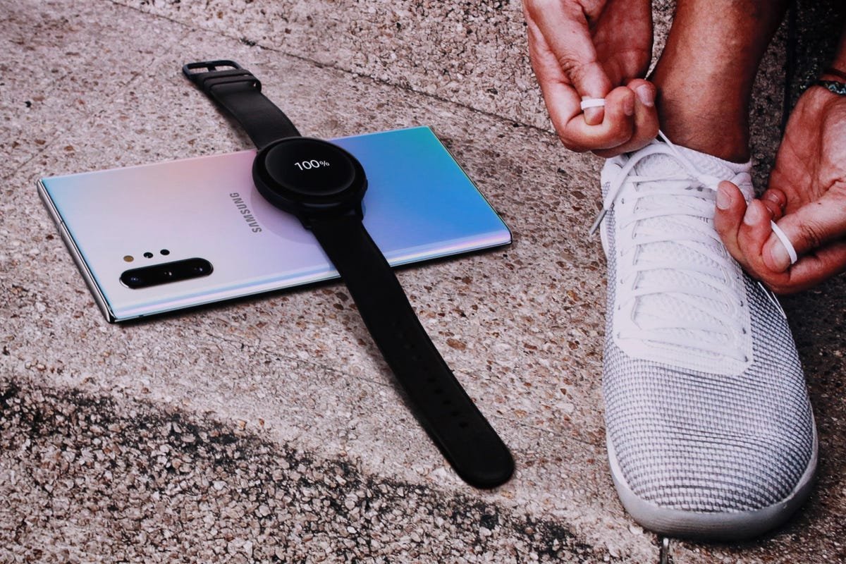Un téléphone Samsung avec une smartwatch Samsung posée dessus