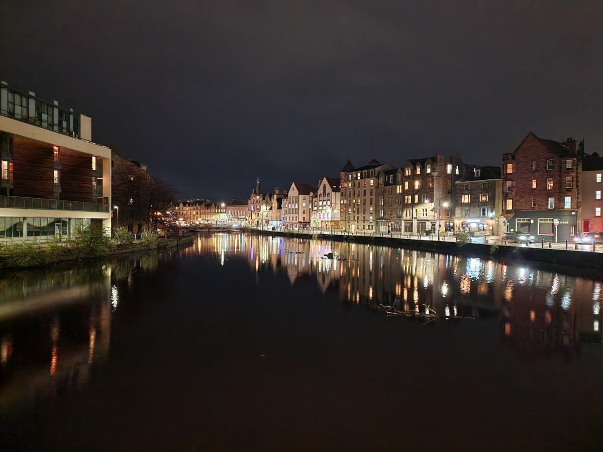 iPhone 14 Pro vs. Pixel 7 Pro, Galaxy S22 Ultra: The Night Mode Test 21 A row of buildings along a river at night