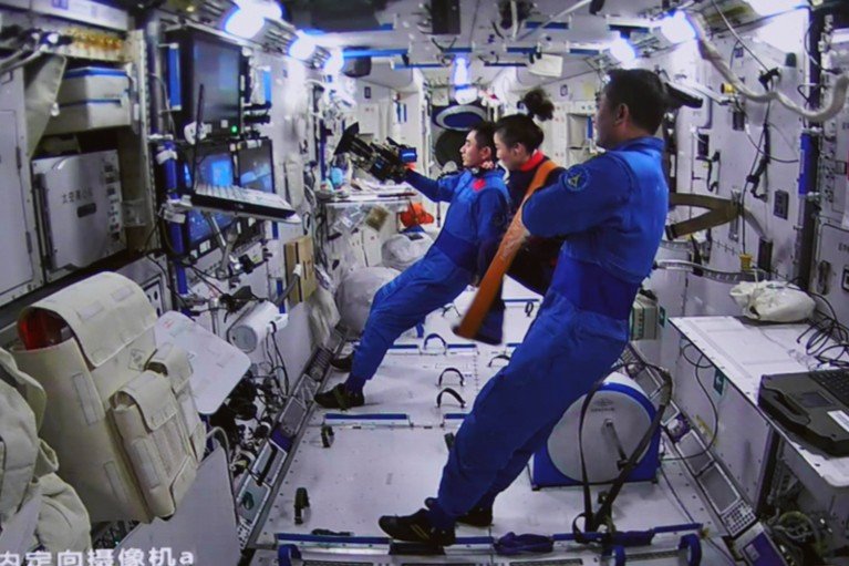 Trois astronautes de Shenzhou-13 regardent un écran sur la station spatiale Tiangong