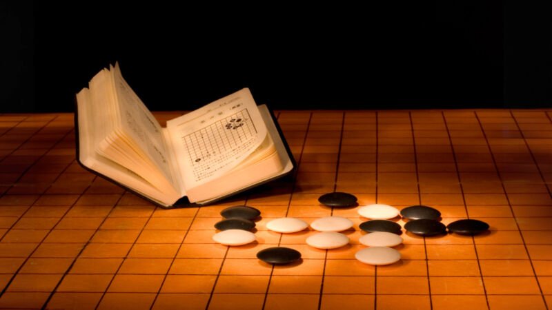 Une nouvelle astuce Go-playing bat le Go AI de classe mondiale, mais perd face aux amateurs humains 1 Pièces de Go et livret de règles sur un plateau de Go.
