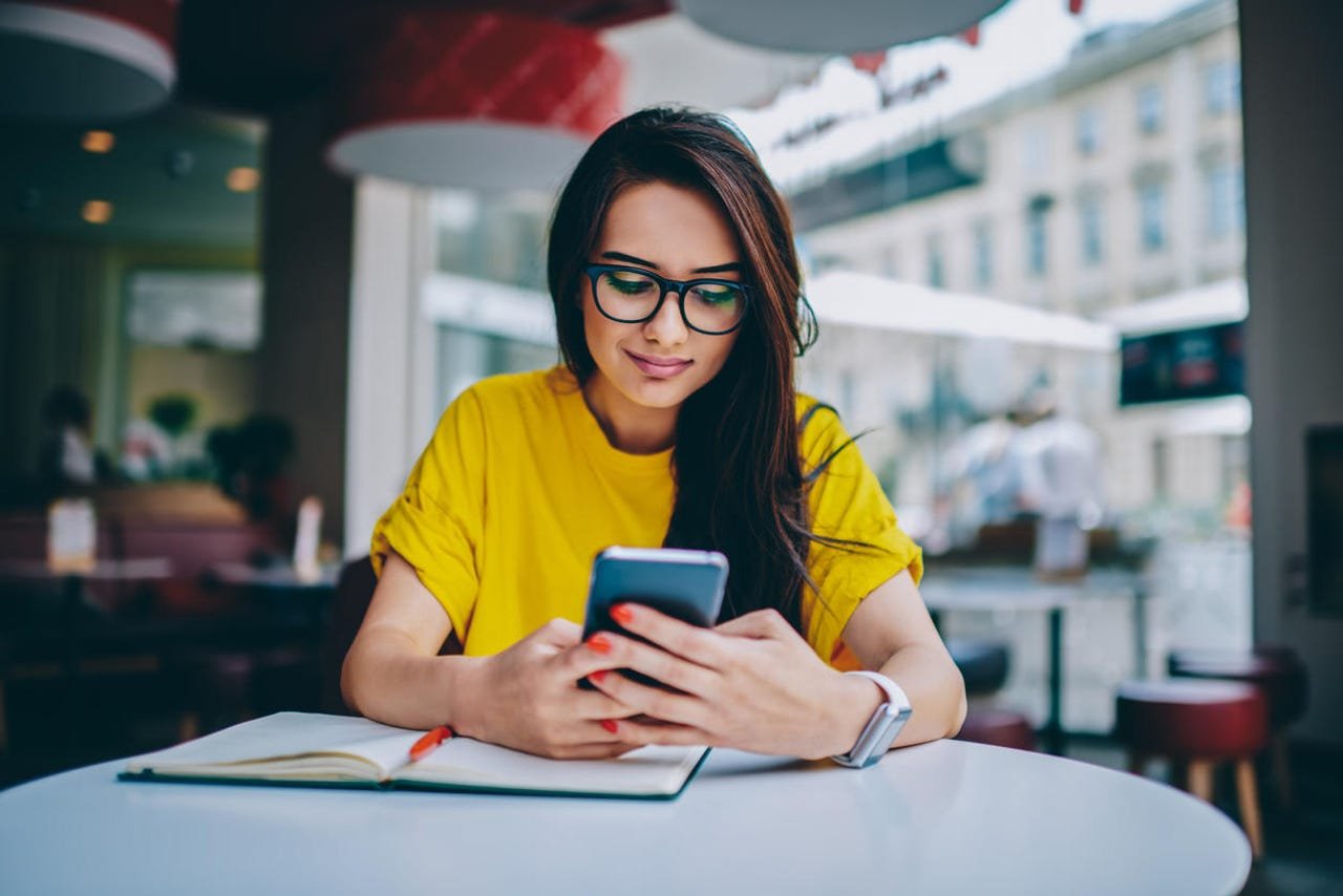 Burger King vient d'enseigner aux utilisateurs d'iPhone et d'Android une brillante leçon 1 Femme utilisant un téléphone à une table