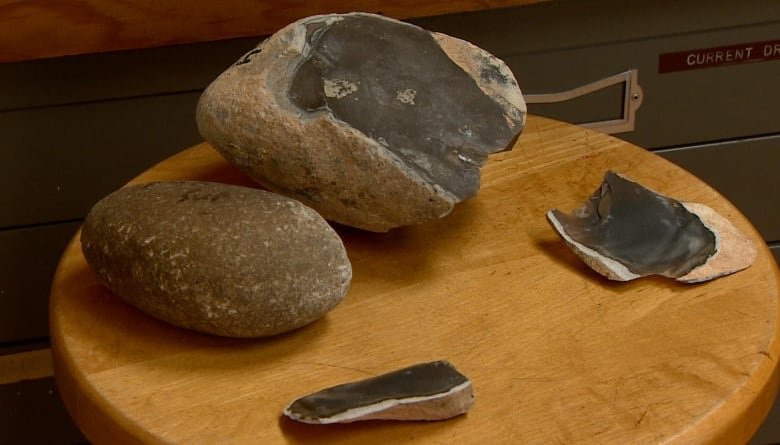 Une pierre ronde et lisse est montrée à côté d'un rocher plus gros auquel il manque deux tranches plus petites.