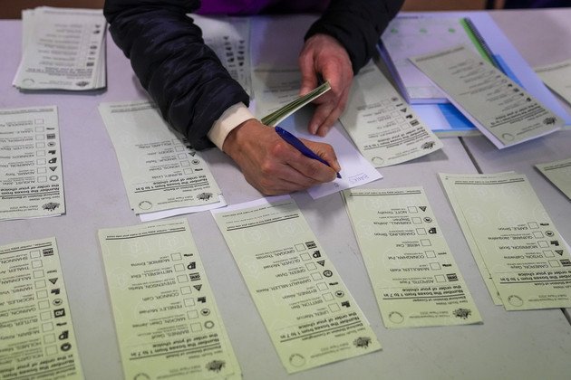 Un responsable électoral prépare les bulletins de vote dans un isoloir à Sydney, en Australie. 