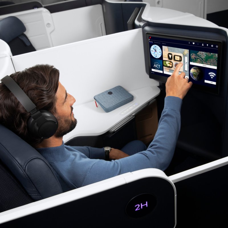 Un homme utilise l'écran de divertissement en classe affaires d'Air France