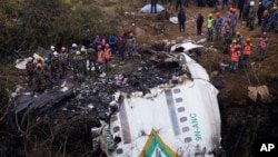 Des sauveteurs parcourent le site de l'accident dans l'épave d'un avion de ligne à Pokhara, au Népal, le 16 janvier 2023.