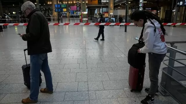 Des personnes se tiennent près d'une bande installée par les autorités après une attaque au couteau dans une gare de Paris Des personnes se tiennent près d'une bande installée par les autorités après une attaque au couteau dans une gare de Paris