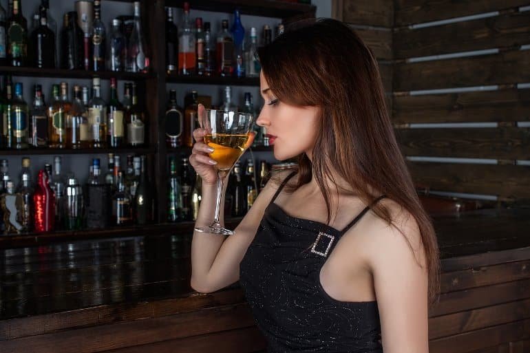 Cela montre une femme tenant un verre