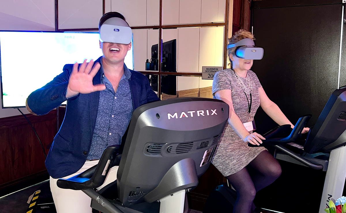 Michael Pihach, rédacteur en chef de PAX, et Mélanie Paul-Hus, directrice pour le Canada chez Atout France, se perdent dans un monde de cyclisme virtuel avec Fit Immersion. 