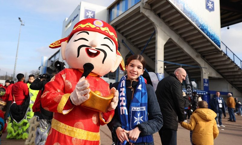 Un fan d'Auxerre pose avec un artiste déguisé en dieu de la fortune à l'extérieur du stade Abbé Deschamps du club d'Auxerre avant un match de Ligue 1 française entre Auxerre et Montpellier dans le cadre des activités de la Journée de la Chine pour célébrer le Nouvel An lunaire chinois à Auxerre, France , 29 janvier 2023. (Photo : Xinhua)