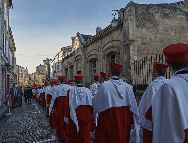 des gens en robe défilant dans la rue de Saint Emilion