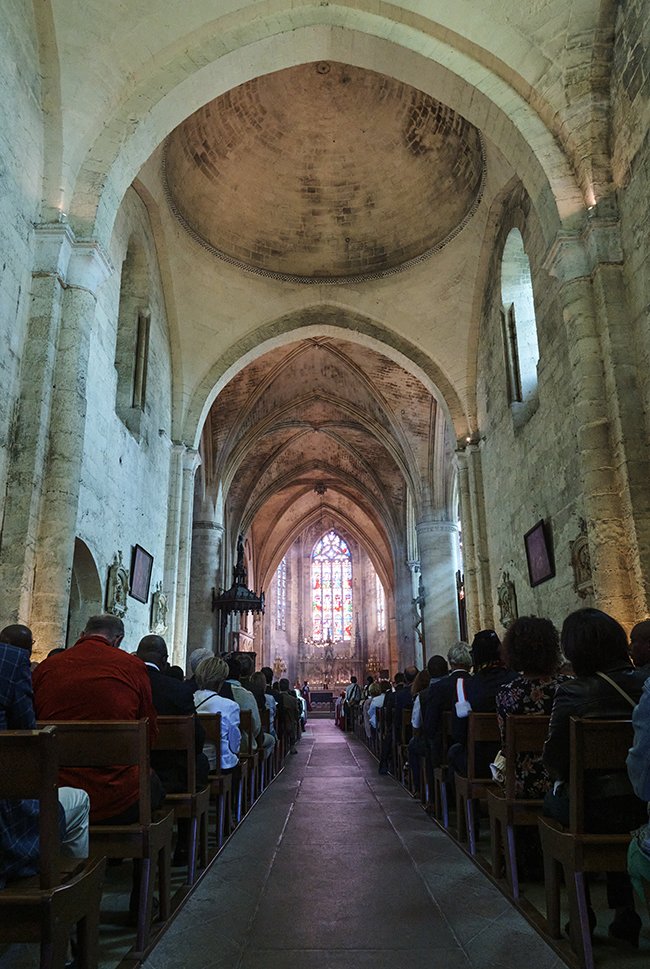 personnes assises en adoration à l'intérieur de l'église