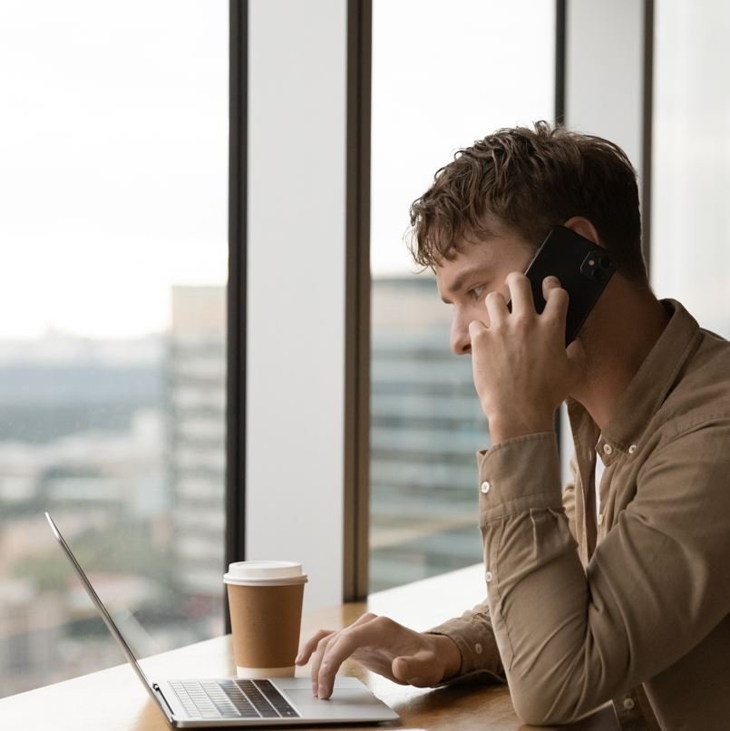 Homme au téléphone à l'ordinateur
