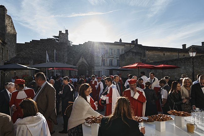 Les gens en robe rouge participant à la fête de la Jurade