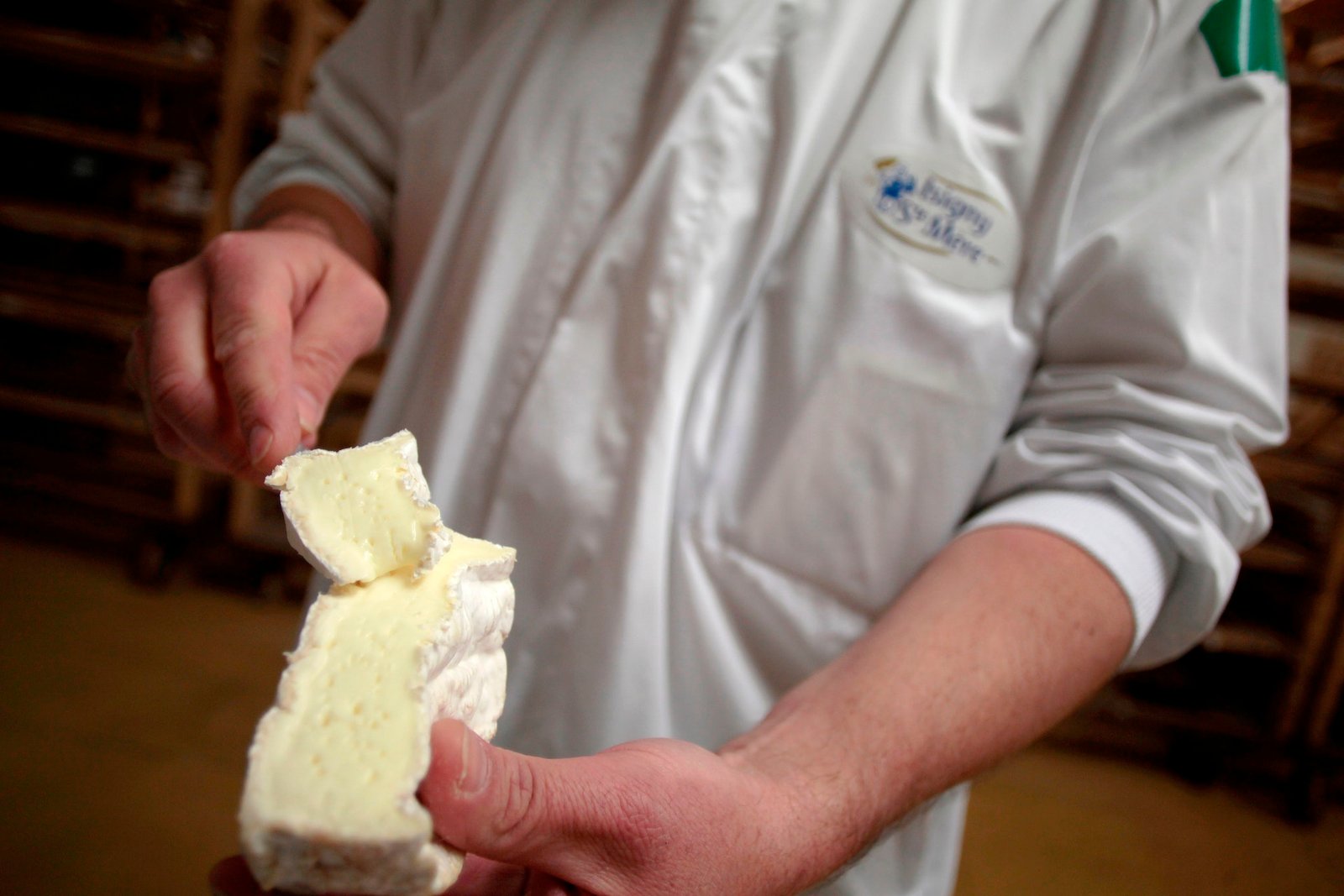 Un employé affiche le camembert français dans une cave de vieillissement à Isigny-Sainte-Mre, Normandie, France