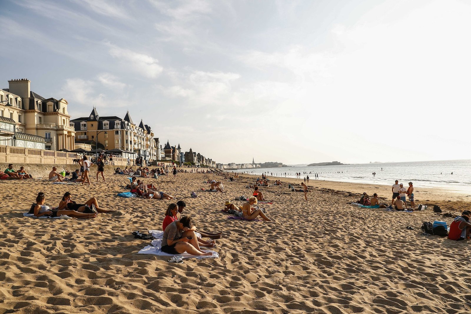 Les touristes bronzent sur une plage au bord de la mer à St-Malo, Bretagne, France