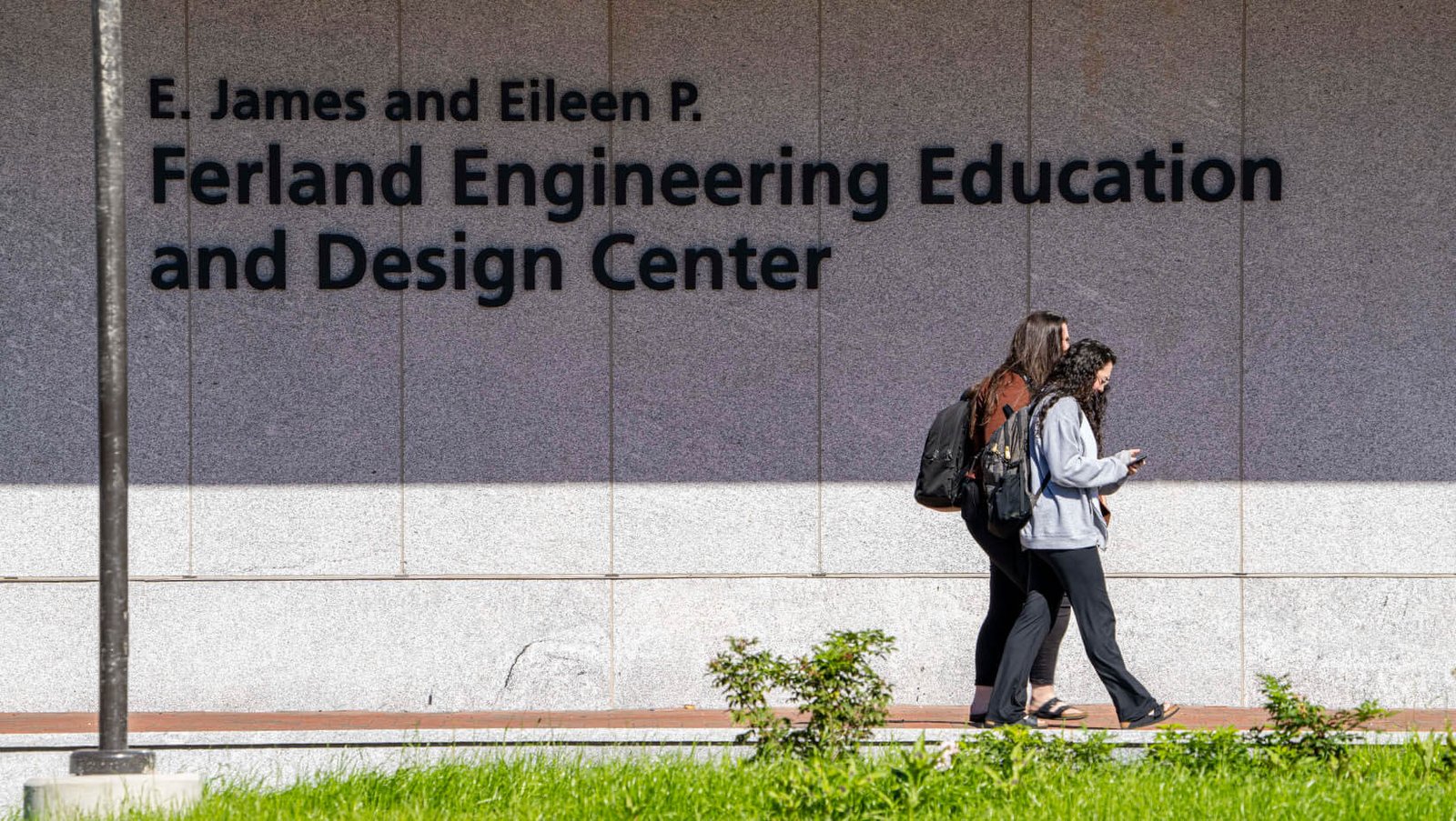 Une photo d'étudiants marchant devant le bâtiment Ferland EEDC de l'UMaine sur le campus