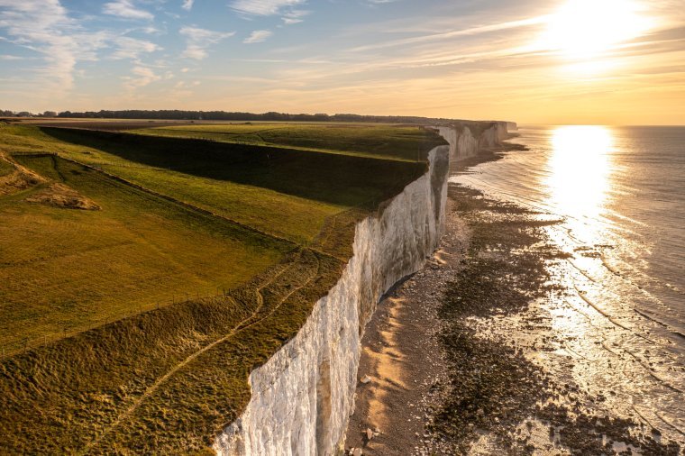France, Somme (80), Ault, Coucher de soleil sur les falaises Picardes et le plateau crayeux qui s'??tend ?? leurs pieds que d??couvre la mar??e (vue a??rienne) // France, Somme (80), Ault, Coucher de soleil sur les falaises picardes et le plateau crayeux qui s'étend à leurs pieds et se découvre par la marée (vue aérienne)