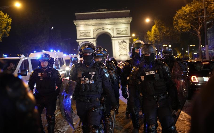 Des personnes en deuil enterrent un adolescent tué en France alors que 45 000 policiers sont déployés et la 5e nuit de troubles est plus calme 1 Des policiers patrouillent devant l'Arc de Triomphe sur les Champs Elysées à Paris, le samedi 1er juillet 2023. Le président Emmanuel Macron a annulé samedi un voyage officiel en Allemagne après une quatrième nuit consécutive d'émeutes et de pillages à travers la France au mépris d'un déploiement policier massif.