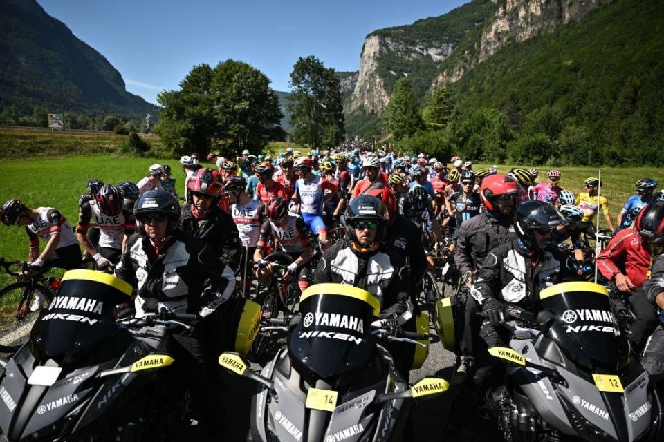 TOPSHOT Le peloton de coureurs est temporairement immobilisé par les régulateurs de course en raison d'une action de protestation sur le parcours lors de la 10ème étape de la 109ème édition du Tour de France cycliste de 1481 km entre Morzine et Megève dans les Alpes françaises le 12 juillet 2022 Photo par Marco BERTORELLO AFP Photo par MARCO BERTORELLOAFP via Getty Images