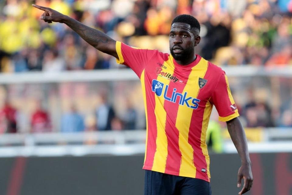 Samuel Umtiti lève son bras en l'air à sa droite et pointe son doigt]