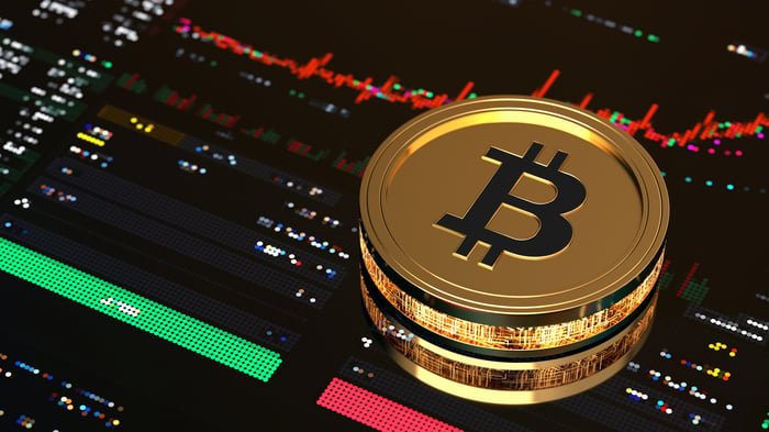 Bitcoin d'or au-dessus d'un écran de négociation boursière.