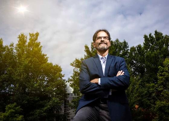 Des scientifiques maçons travailleront avec la marine américaine pour éviter une apocalypse sur Internet 1 Peter Becker se tient dehors, au soleil, devant un groupe d'arbres, les yeux tournés vers le ciel.