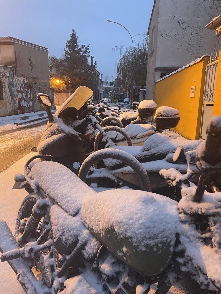 La neige recouvre les scooters alignés dans une rue de Paris, le 18 janvier 2024