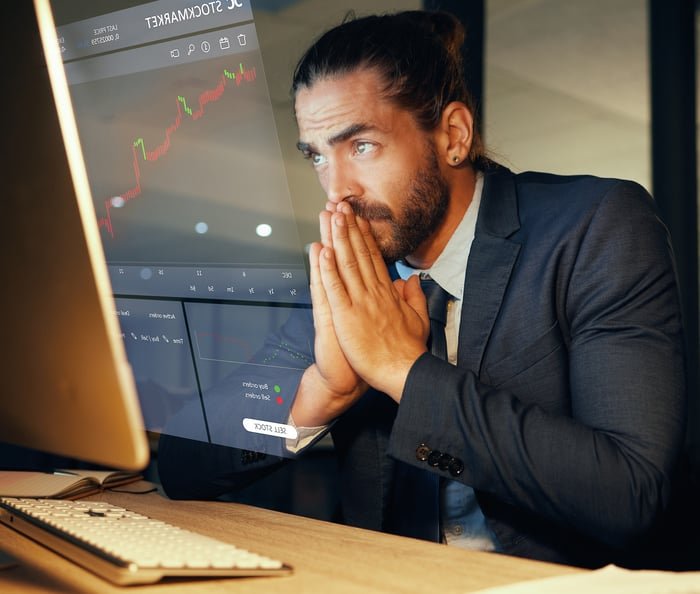 Homme tendu regardant les graphiques boursiers