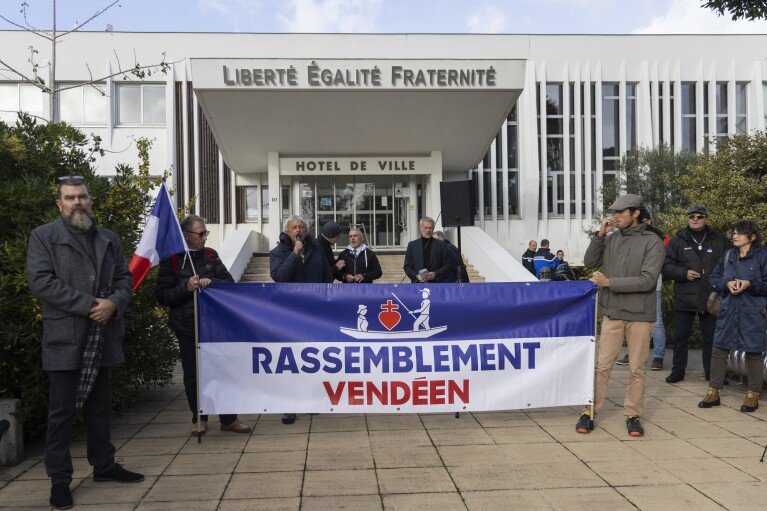 Pierre Cassen, au centre, militant d'extrême droite, s'adresse aux personnes rassemblées devant l'hôtel de ville de Saint-Jean-de-Monts, dans l'ouest de la France, le samedi 4 novembre 2023. Le petit mouvement connu sous le nom de Rassemblement de Vendée, appelle les agriculteurs et les pêcheurs pour protester contre les immigrants et les importations étrangères.  (Photo AP/Jeremias Gonzalez)