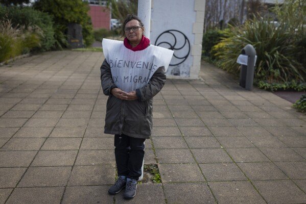 Une personne favorable à l'accueil des migrants observe des personnes manifestant à Saint-Jean-de-Monts, le samedi 4 novembre 2023, à l'appel du groupe d'extrême droite contre l'accueil dans la commune de 15 migrants.  Le petit mouvement connu sous le nom de Rassemblement de Vendée appelle les agriculteurs et les pêcheurs à protester contre les immigrants et les importations étrangères.  (Photo AP/Jeremias Gonzalez)