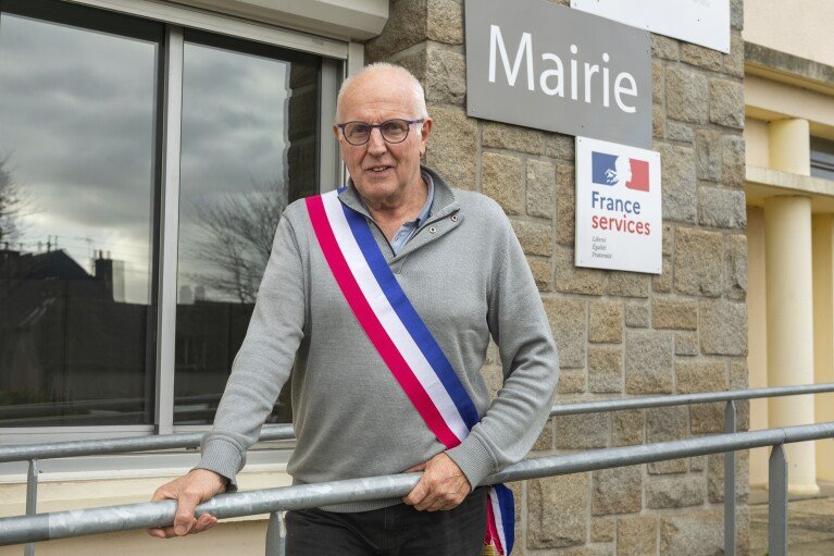 Jean-Yves Rolland, maire de Callac, pose devant la mairie le 15 décembre 2023. L'extrême droite a crié victoire en janvier 2023, lorsque Rolland a renoncé à son projet d'héberger sept à dix familles de réfugiés.  (Photo AP/Mathieu Pattier)