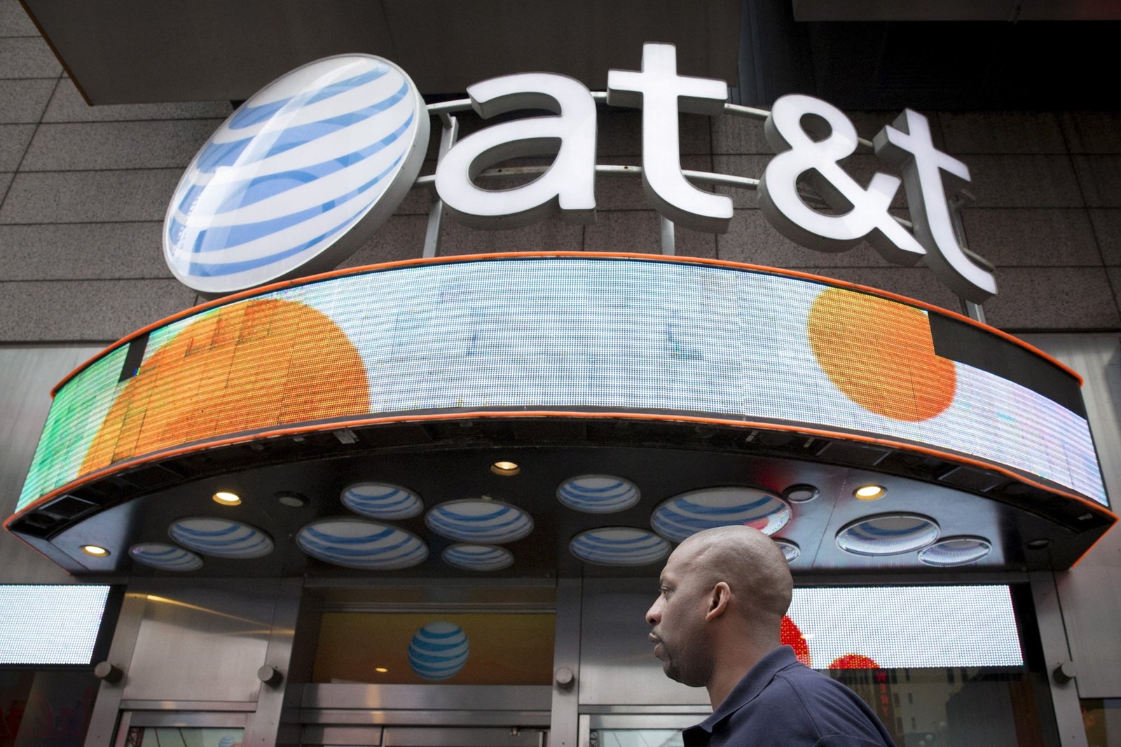 PHOTO : Un homme passe devant le magasin AT&T à Times Square à New York, le 17 juin 2015.