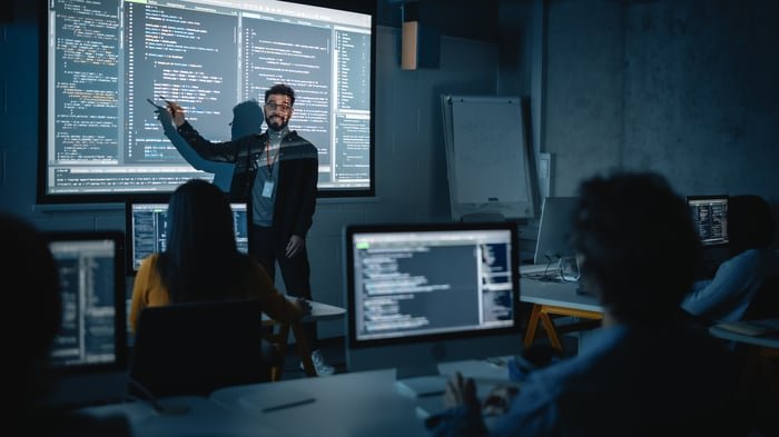 Personnes écrivant du code informatique dans un environnement de travail.