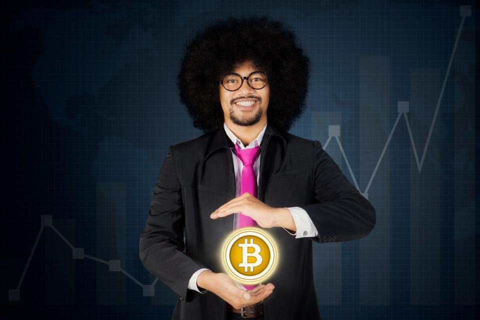 Une personne en costume tient une sphère Bitcoin lumineuse devant un graphique ascendant.